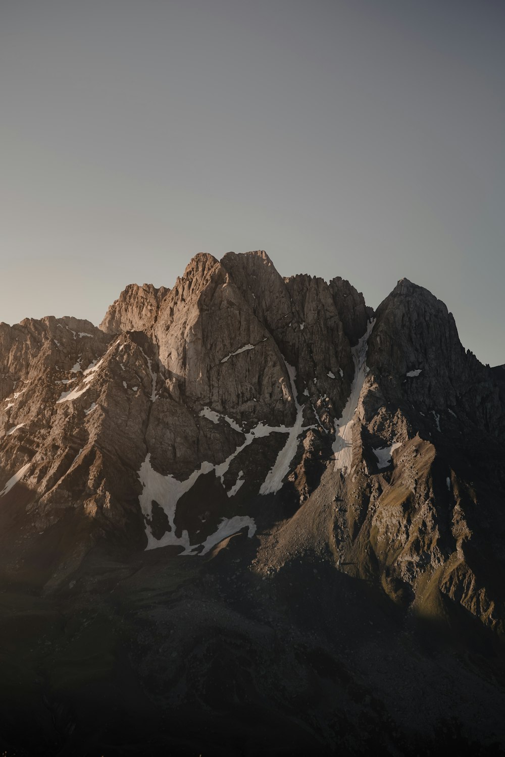 brown rocky mountain under gray sky