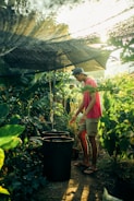 woman in pink tank top and white shorts standing under gray umbrella during daytime