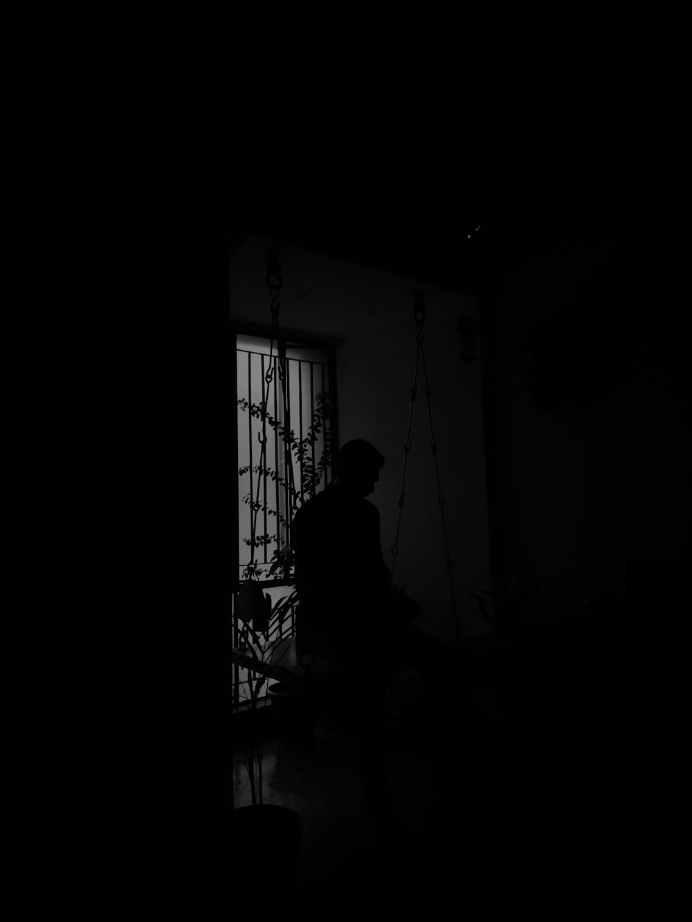 silhouette of man standing near window