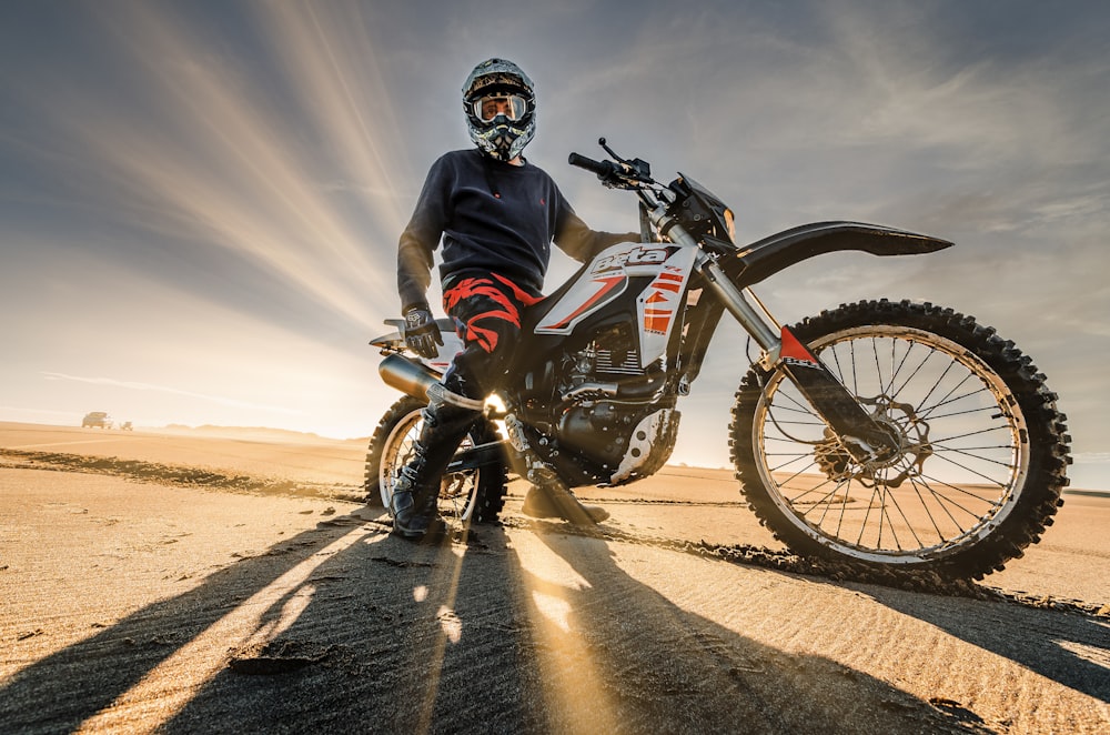 man in black and red motorcycle suit riding on red and white motocross dirt bike