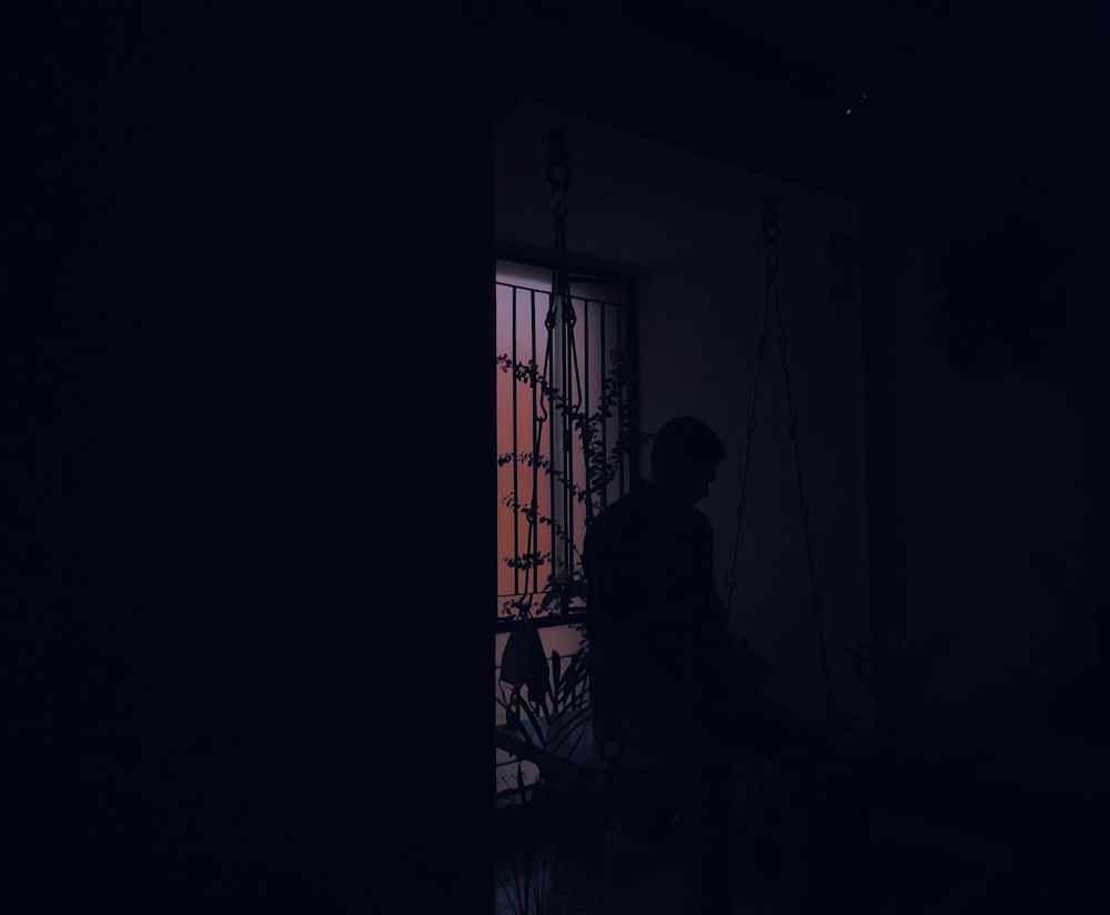 silhouette of person standing near window