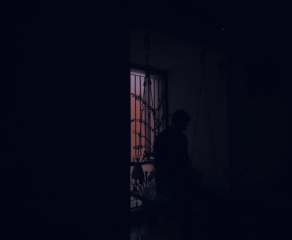 Silhouette der Person, die in der Nähe des Fensters steht