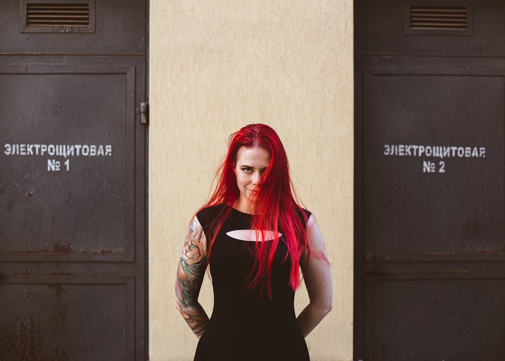 woman in black tank top standing beside black door