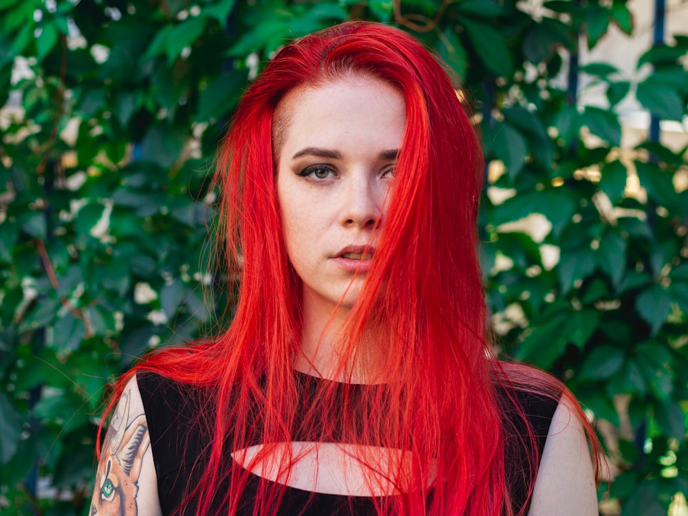 woman in red hair wearing white and black sleeveless top