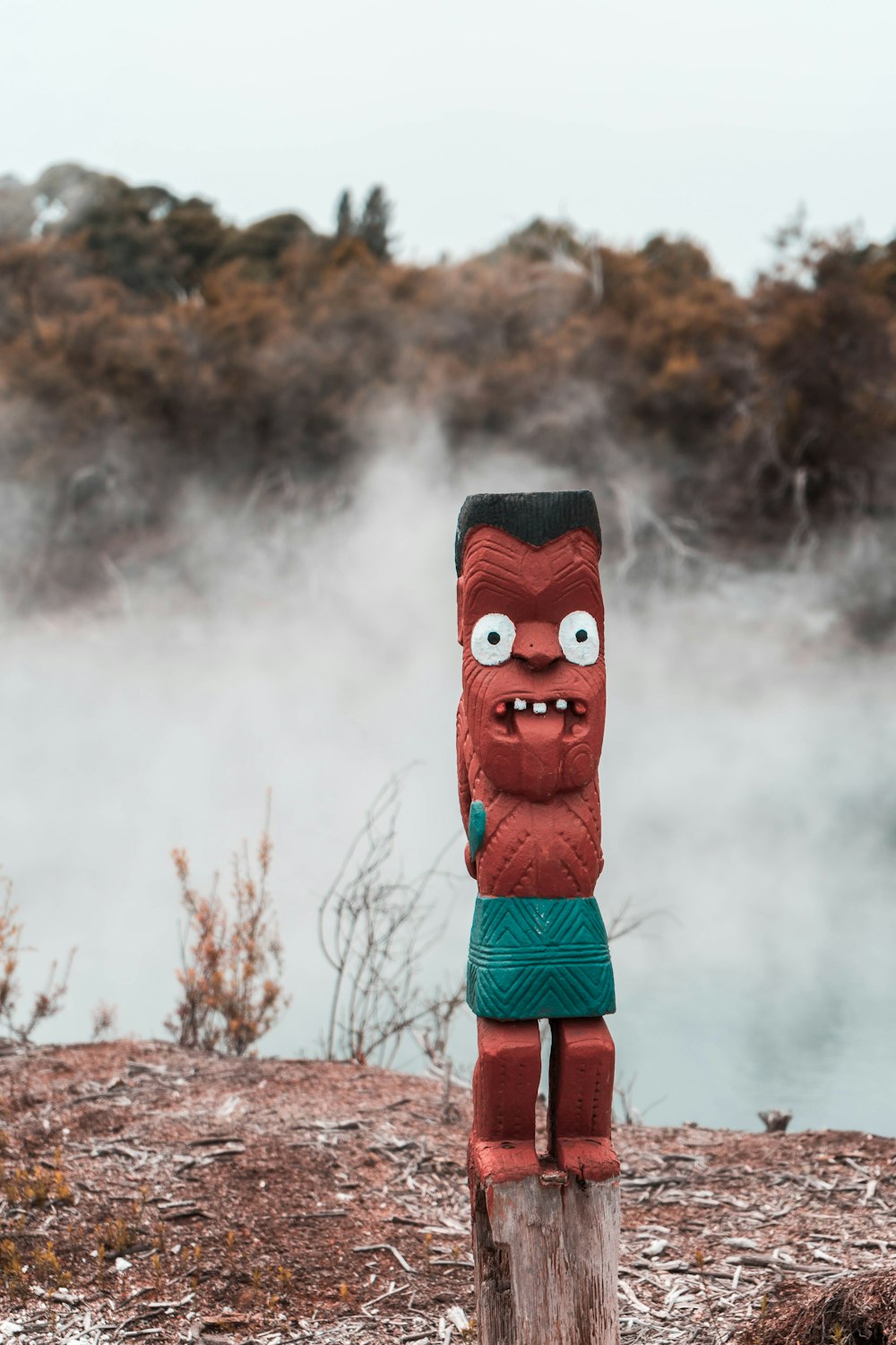 Máscara roja y negra en campo de hierba marrón