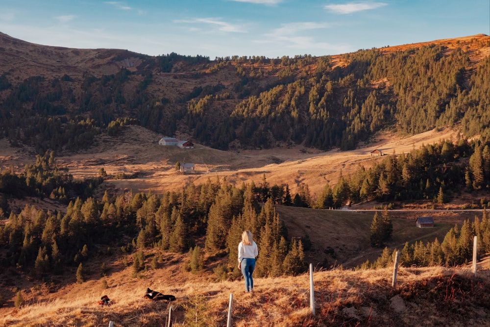 woman in white jacket standing on brown field during daytime