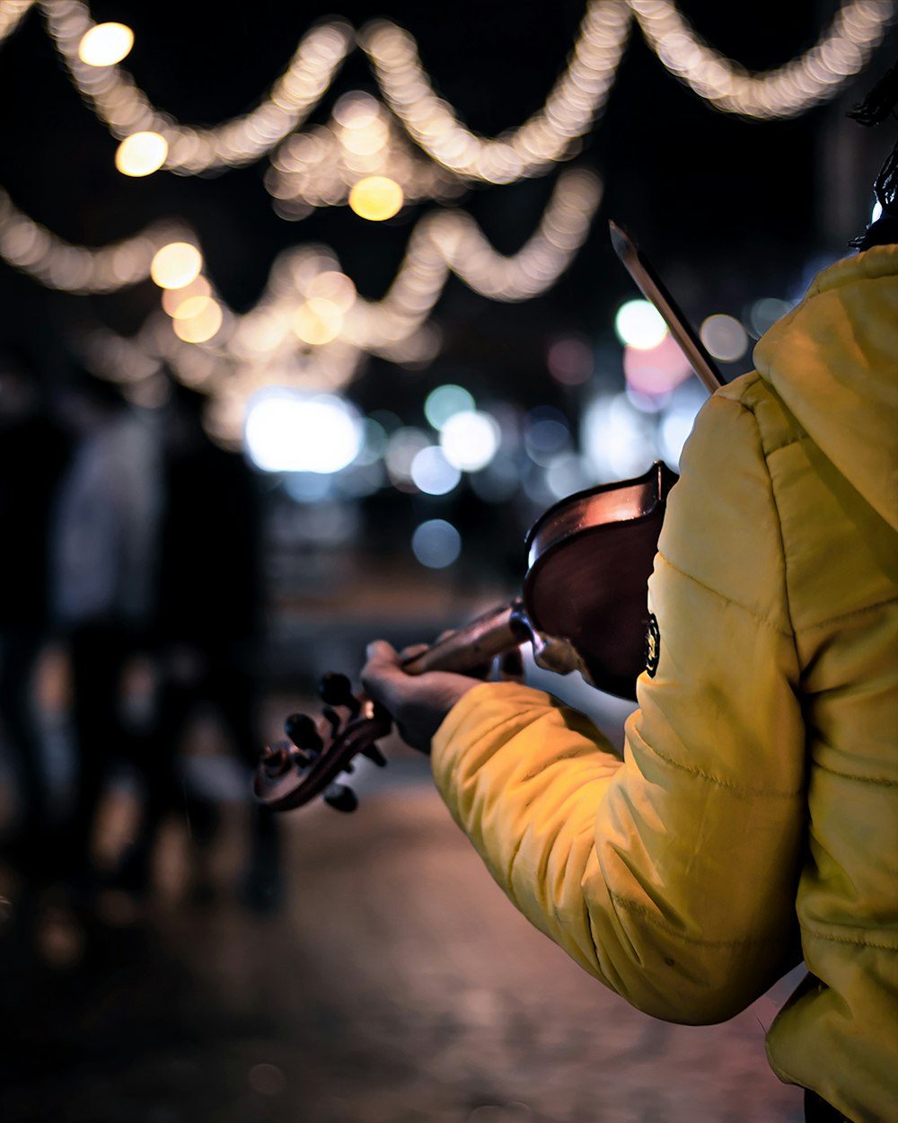 person in yellow jacket playing violin