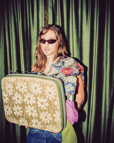 A vibrant patterned scarf draped over a vintage suitcase, evoking timeless travel vibes.