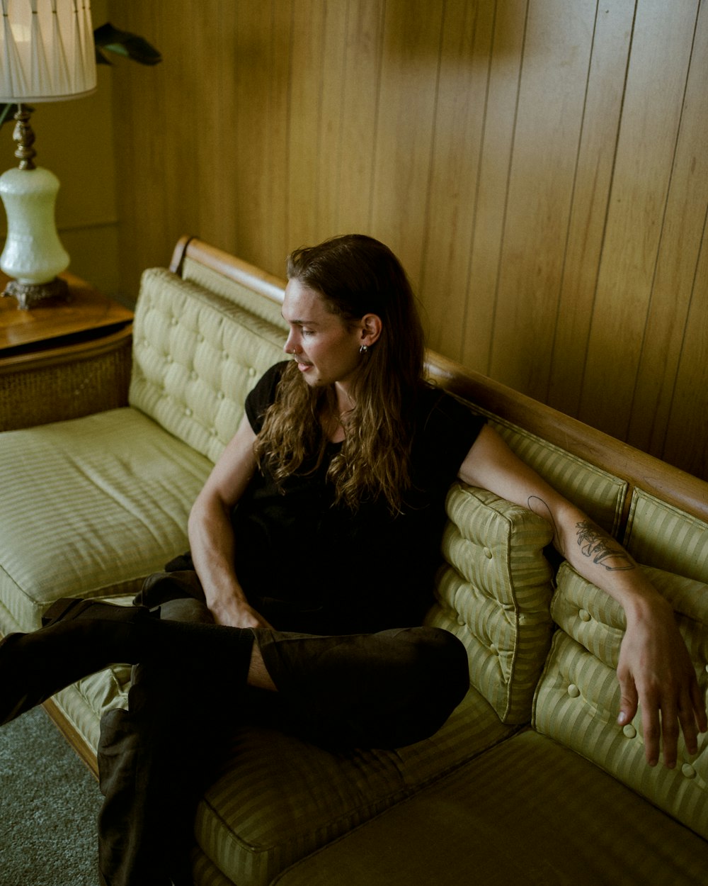 man in black t-shirt sitting on sofa