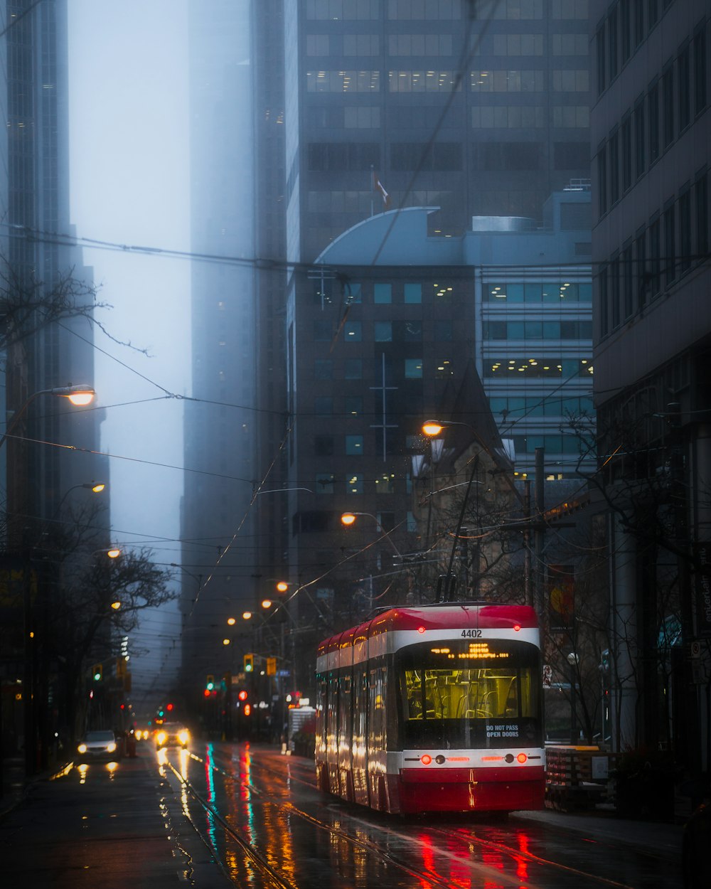 red and white bus on road during night time