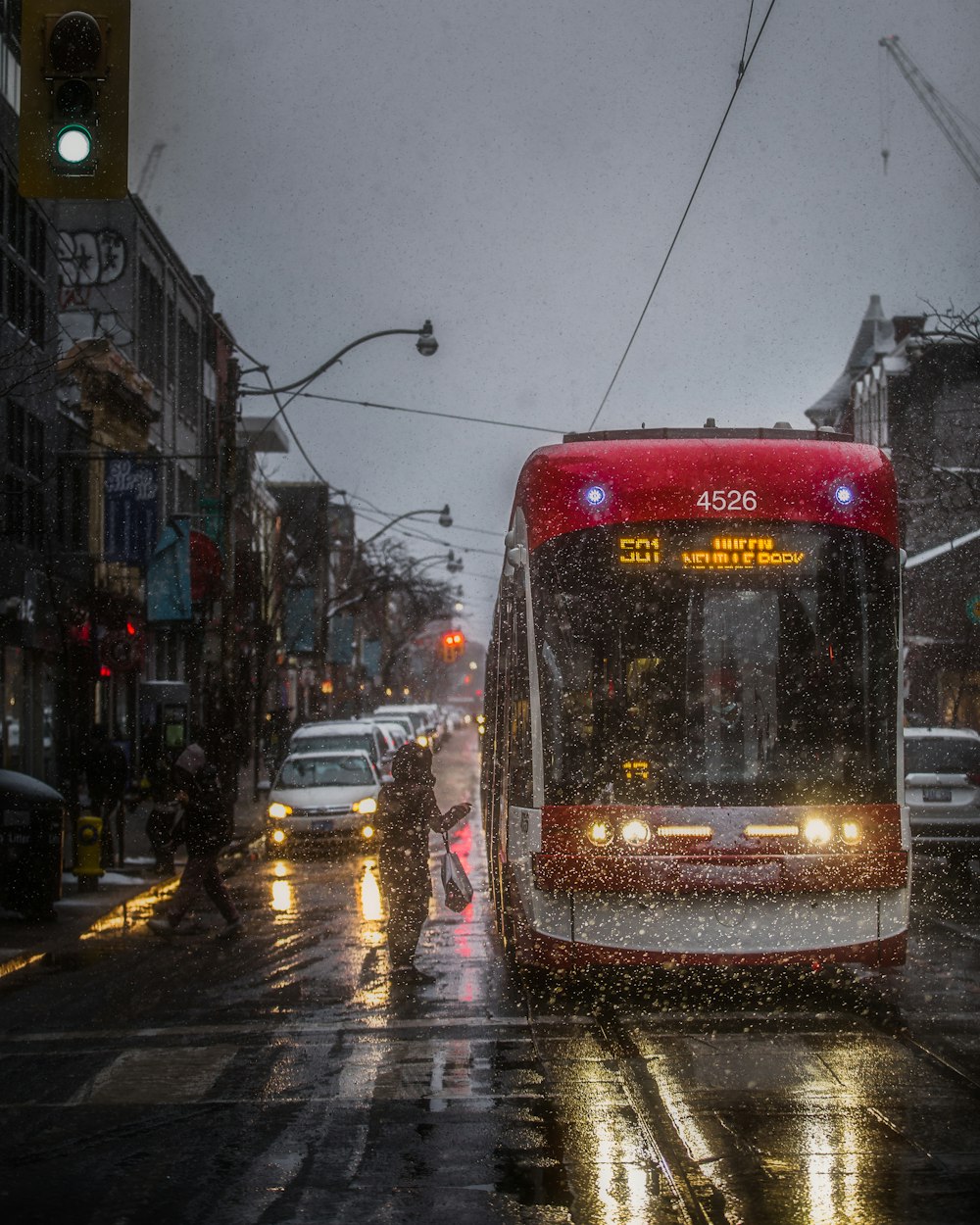 red and white tram on road during night time