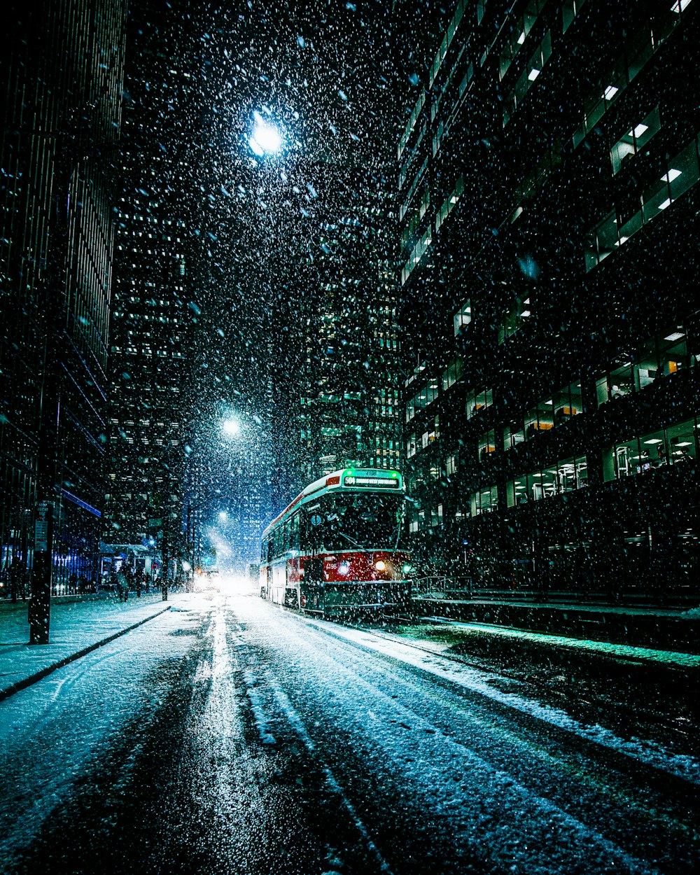 cars on road between high rise buildings during night time