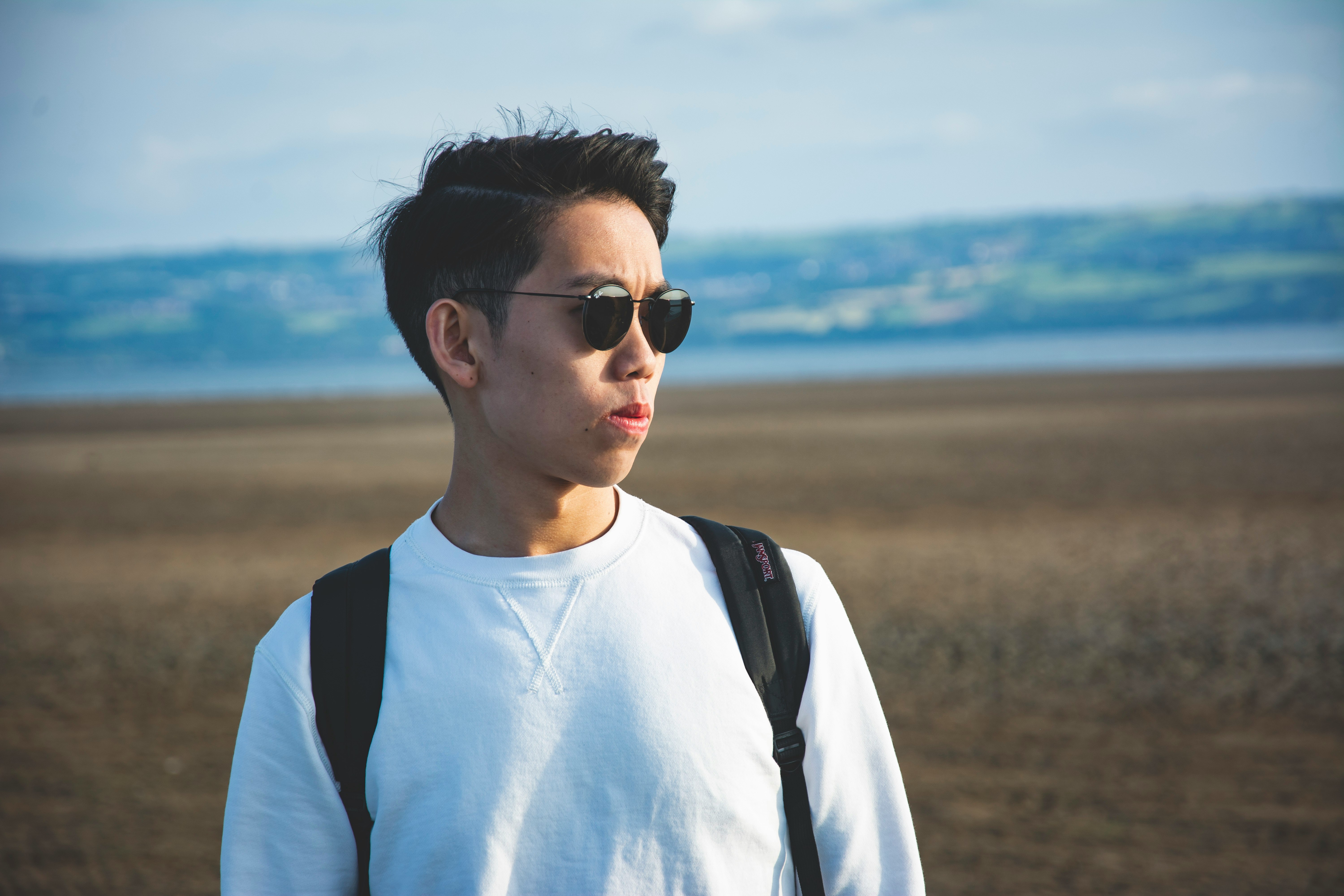 man in white crew neck shirt wearing black sunglasses