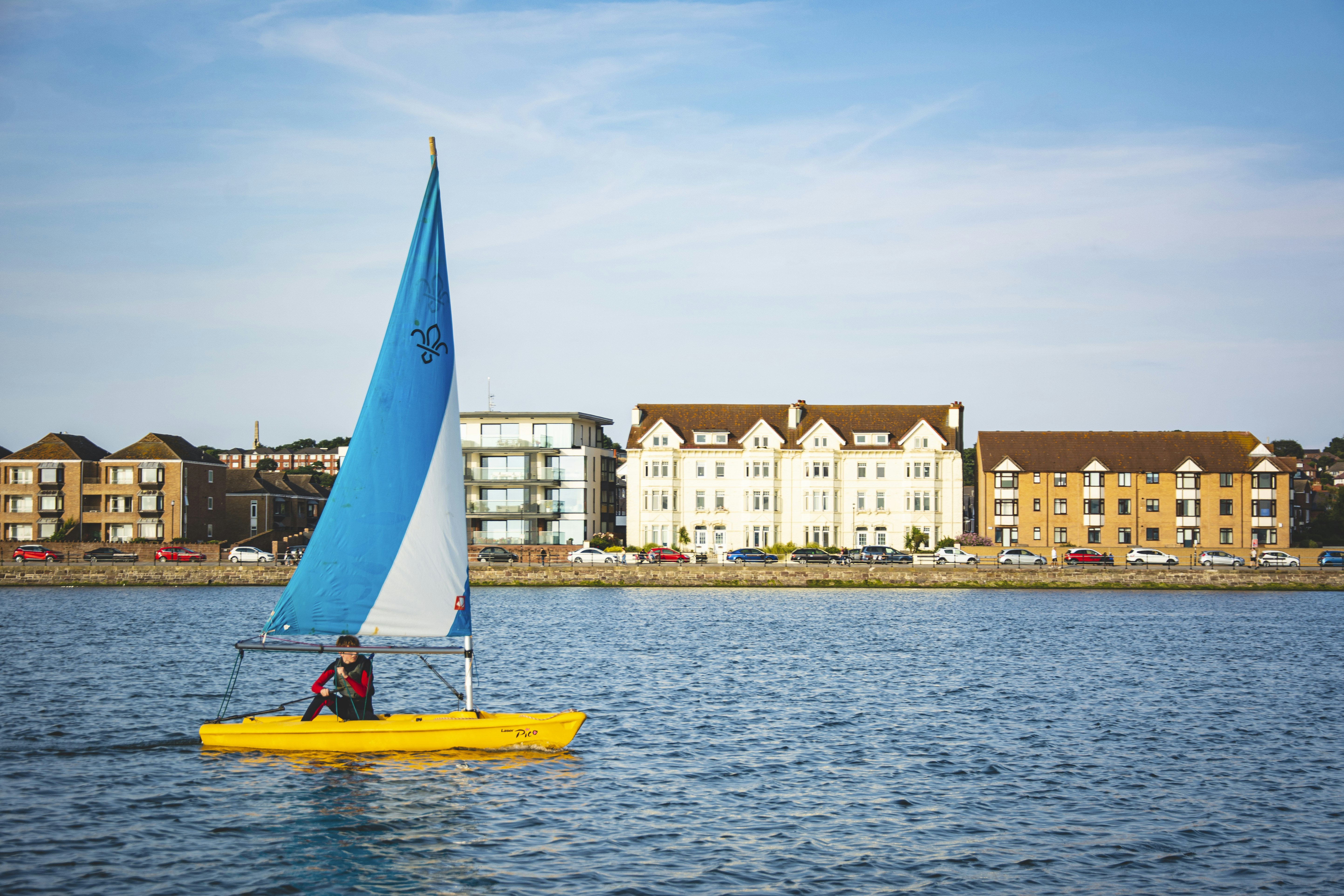 yellow boat on sea near buildings during daytime