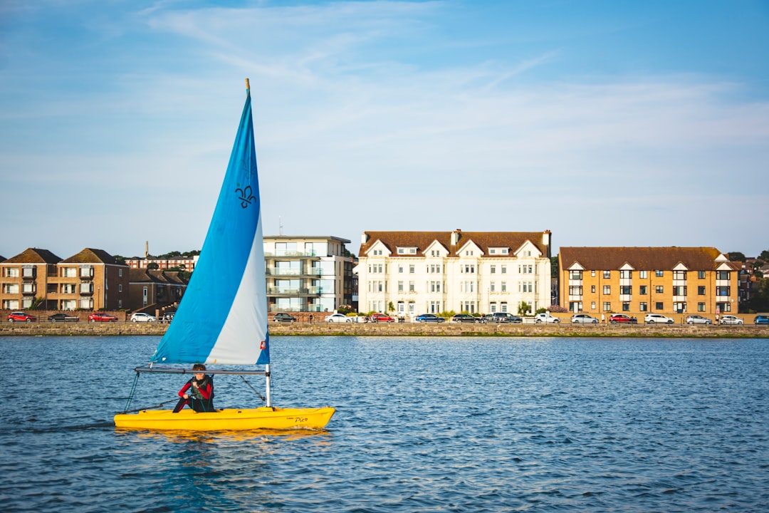 yellow boat on sea near buildings during daytime