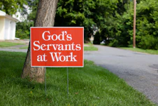 white and black wooden signage on green grass field