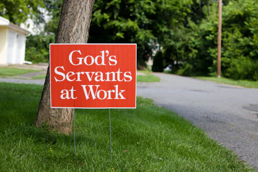 white and black wooden signage on green grass field