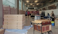 Wide view of a workshop space filled with cardboard materials and creative projects in progress.