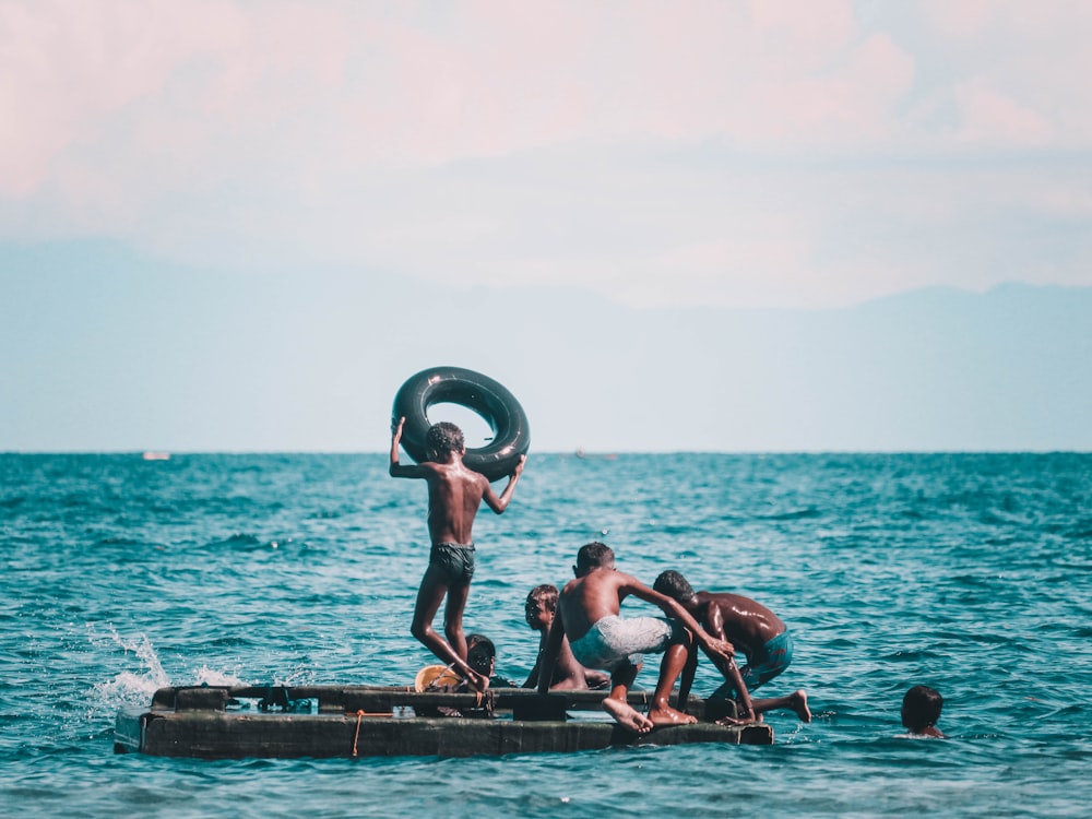 3 women in black bikini on sea dock during daytime