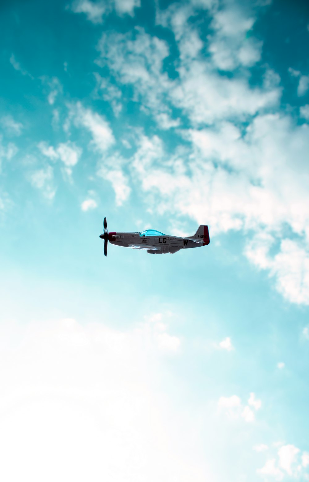 blue and white airplane flying in the sky during daytime