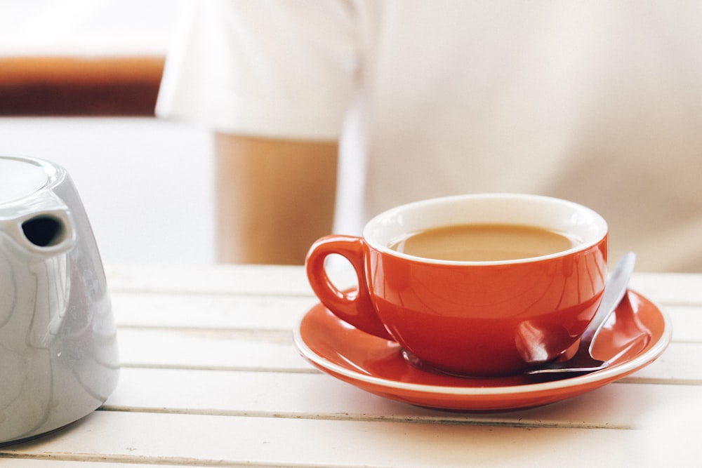 red ceramic cup on saucer