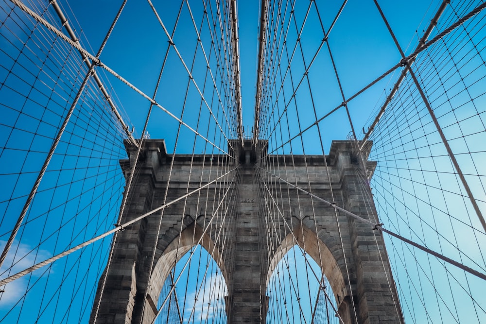 low angle photography of gray concrete bridge under blue sky during daytime