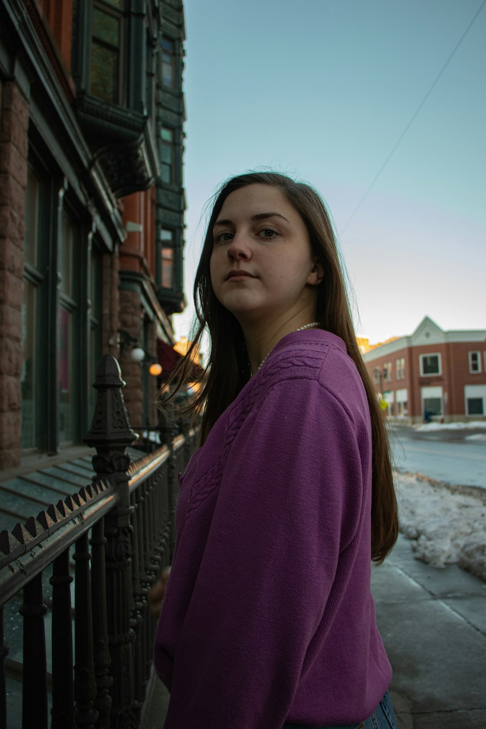 woman in purple long sleeve shirt standing on snow covered ground during daytime