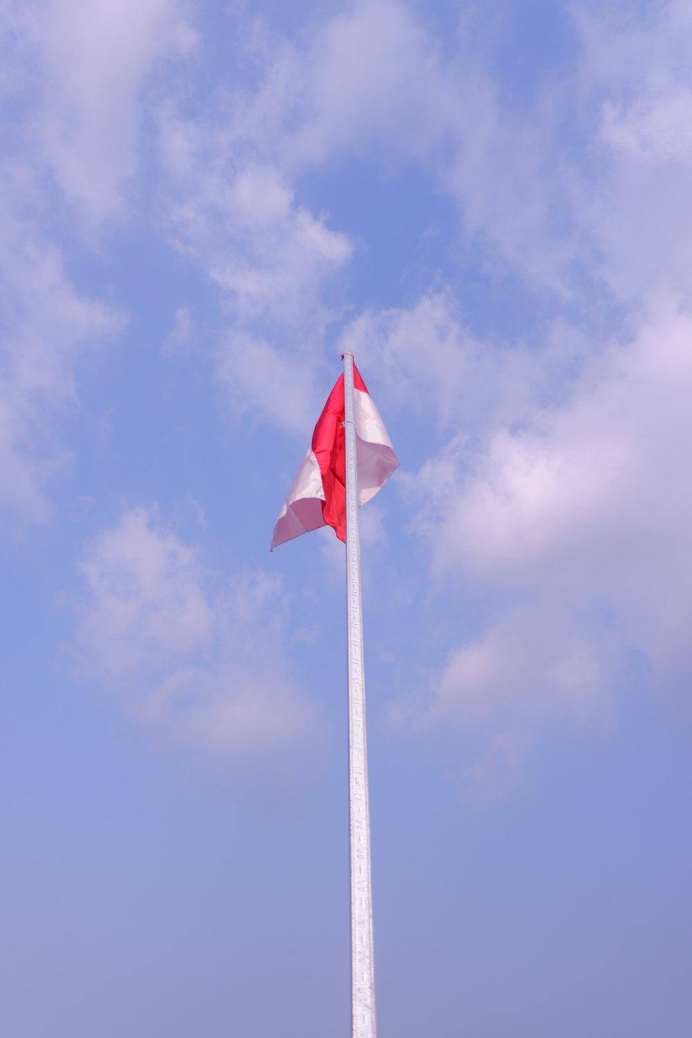 drapeau rouge et blanc sous ciel bleu pendant la journée