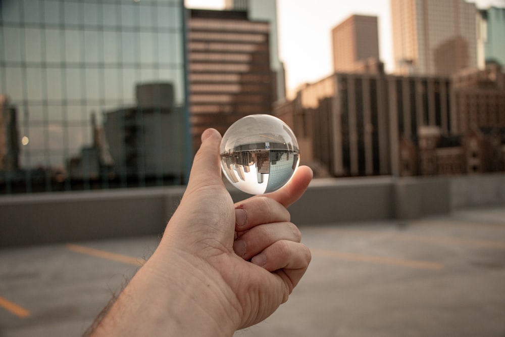 person holding clear glass ball