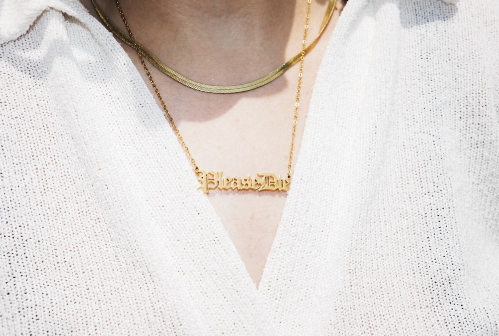 woman in white v neck shirt wearing gold necklace
