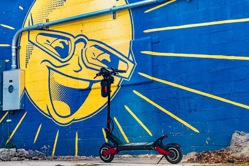 black and red stroller beside blue and yellow wall