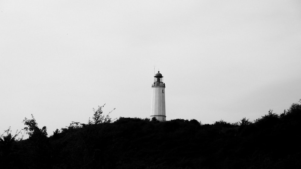 white lighthouse on top of hill