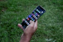 A happy user interacting with an Android app on a smartphone outdoors.