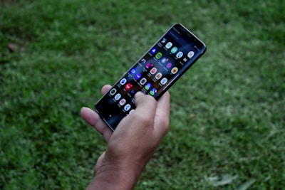 Mobile app interface displayed on a smartphone held by a user outdoors.