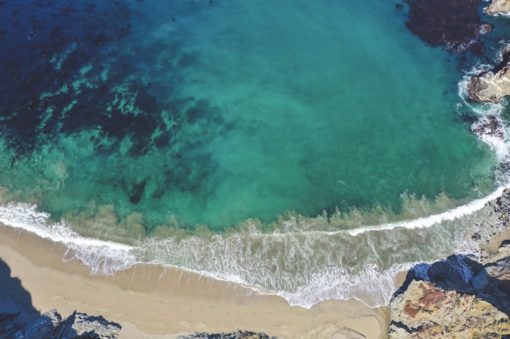 aerial view of ocean waves on shore during daytime