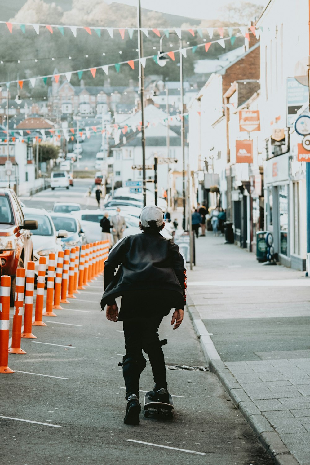 man in black jacket walking on sidewalk during daytime