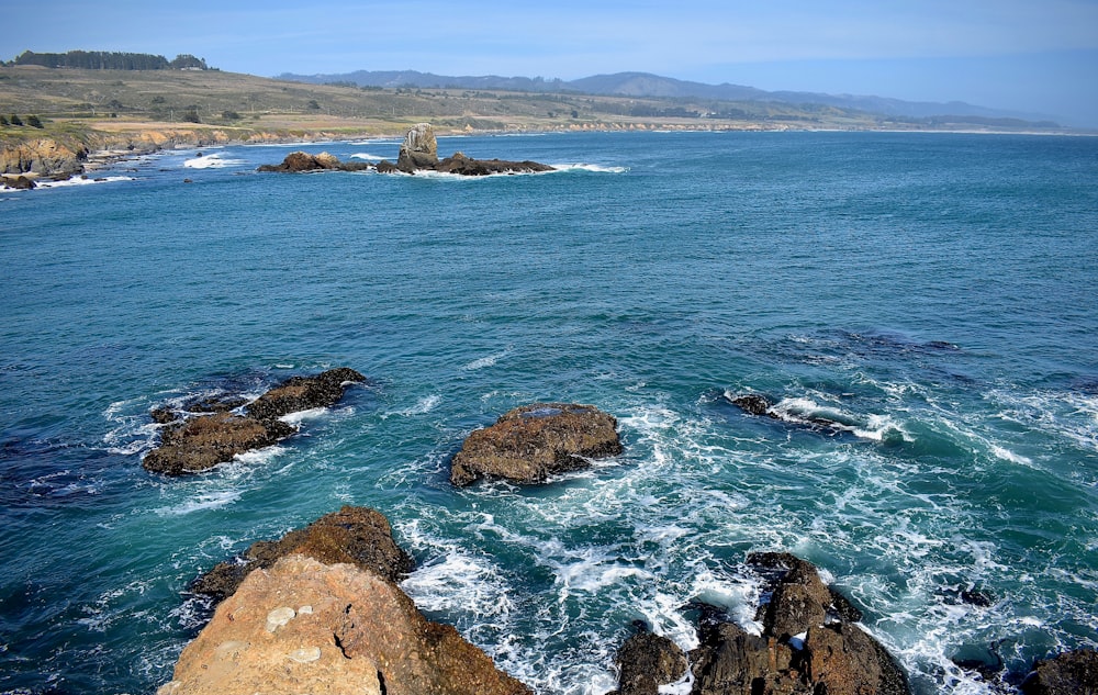 brown rock formation on sea during daytime