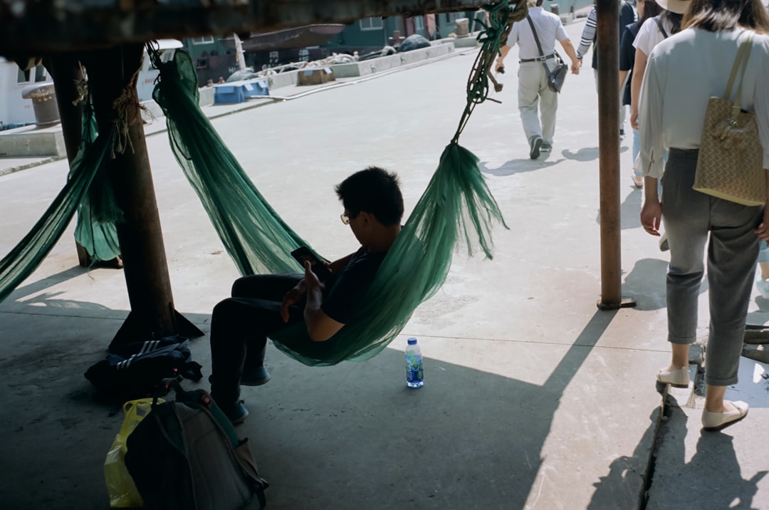 man in green shirt sitting on hammock