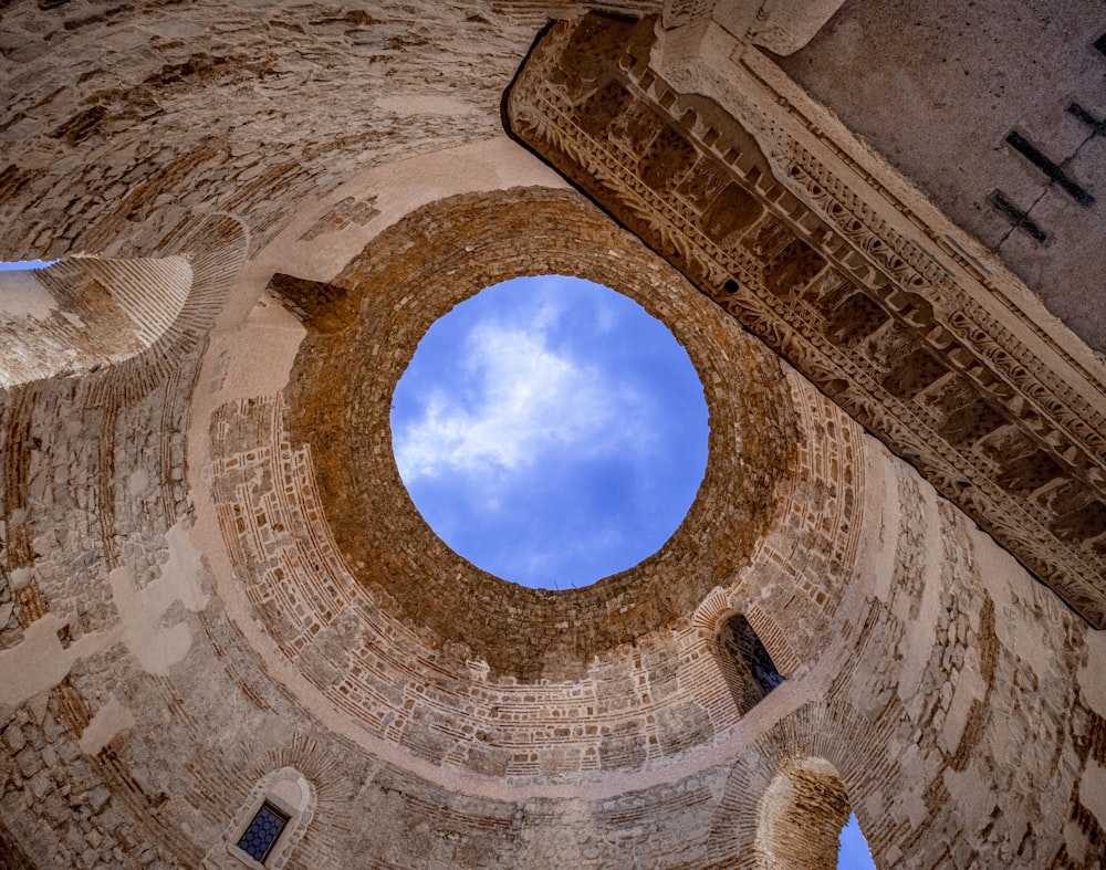 low angle photography of brown concrete building under blue sky during daytime