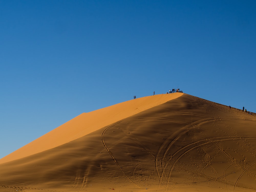 people walking on sand dunes during daytime