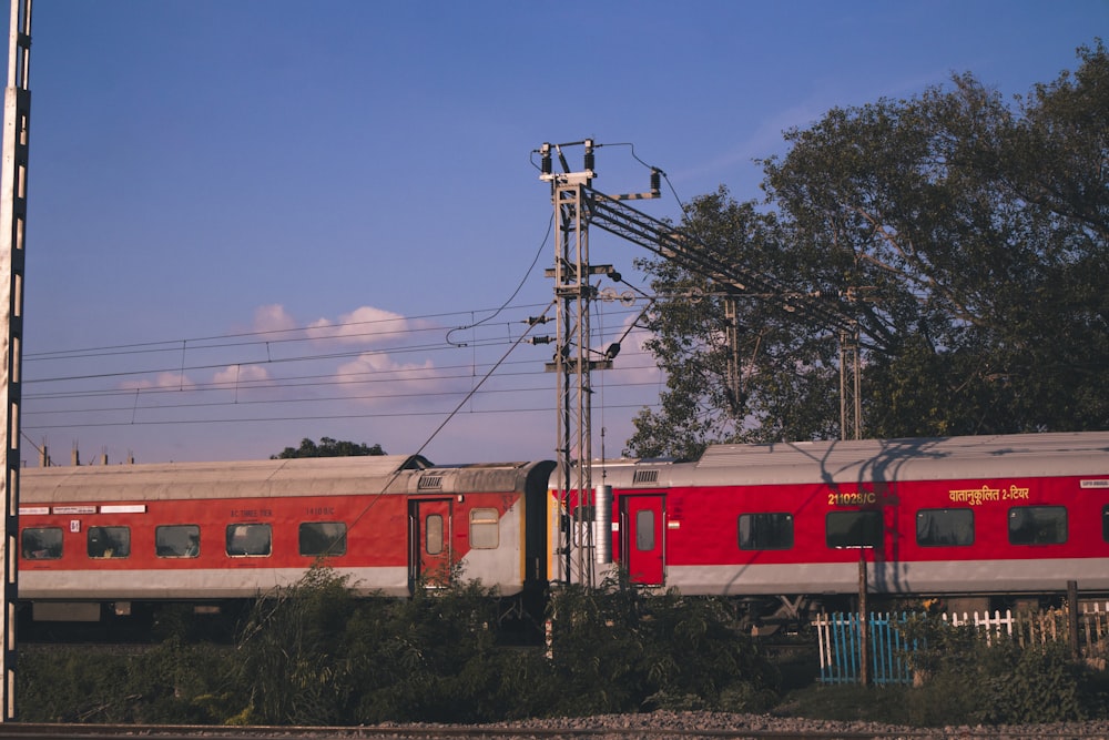 trem vermelho e branco no trilho sob o céu azul durante o dia