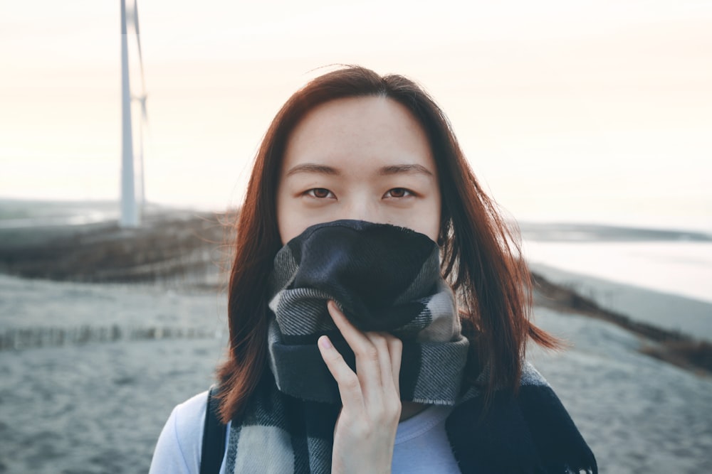 woman in black and white scarf holding black mask