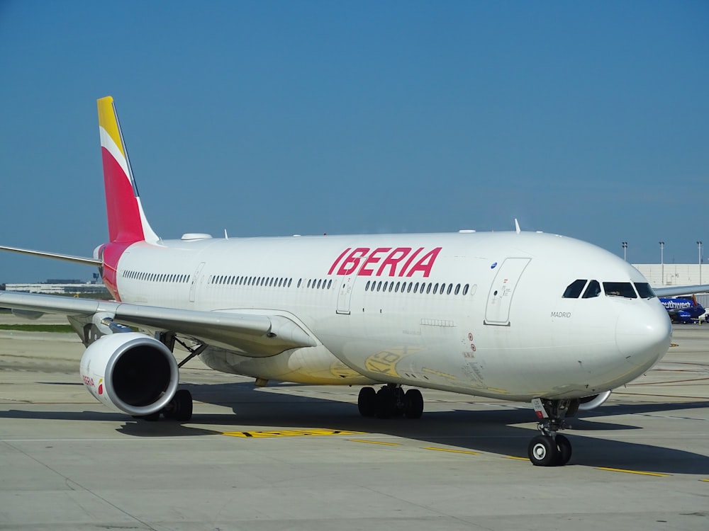 white and red air plane on airport during daytime