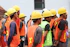 man in orange vest wearing yellow hard hat