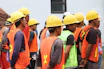 man in orange vest wearing yellow hard hat