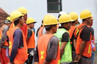 man in orange vest wearing yellow hard hat