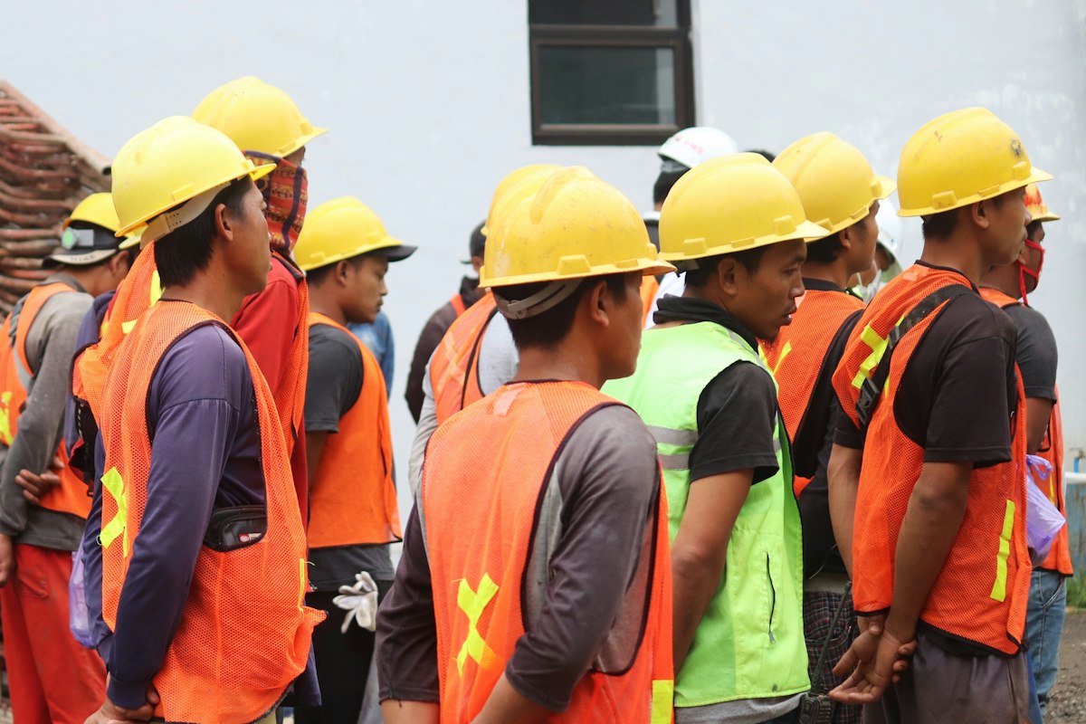 Workers in hard hats and safety vests at a workplace health visit