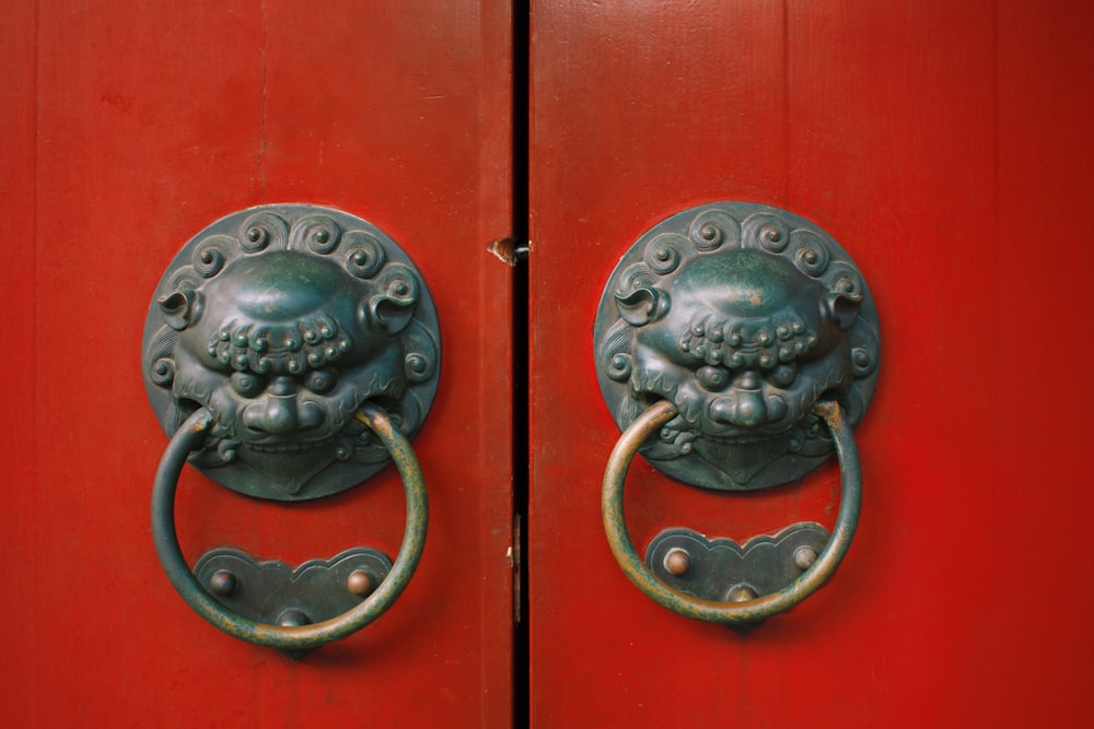 black steel door knob on red wooden door