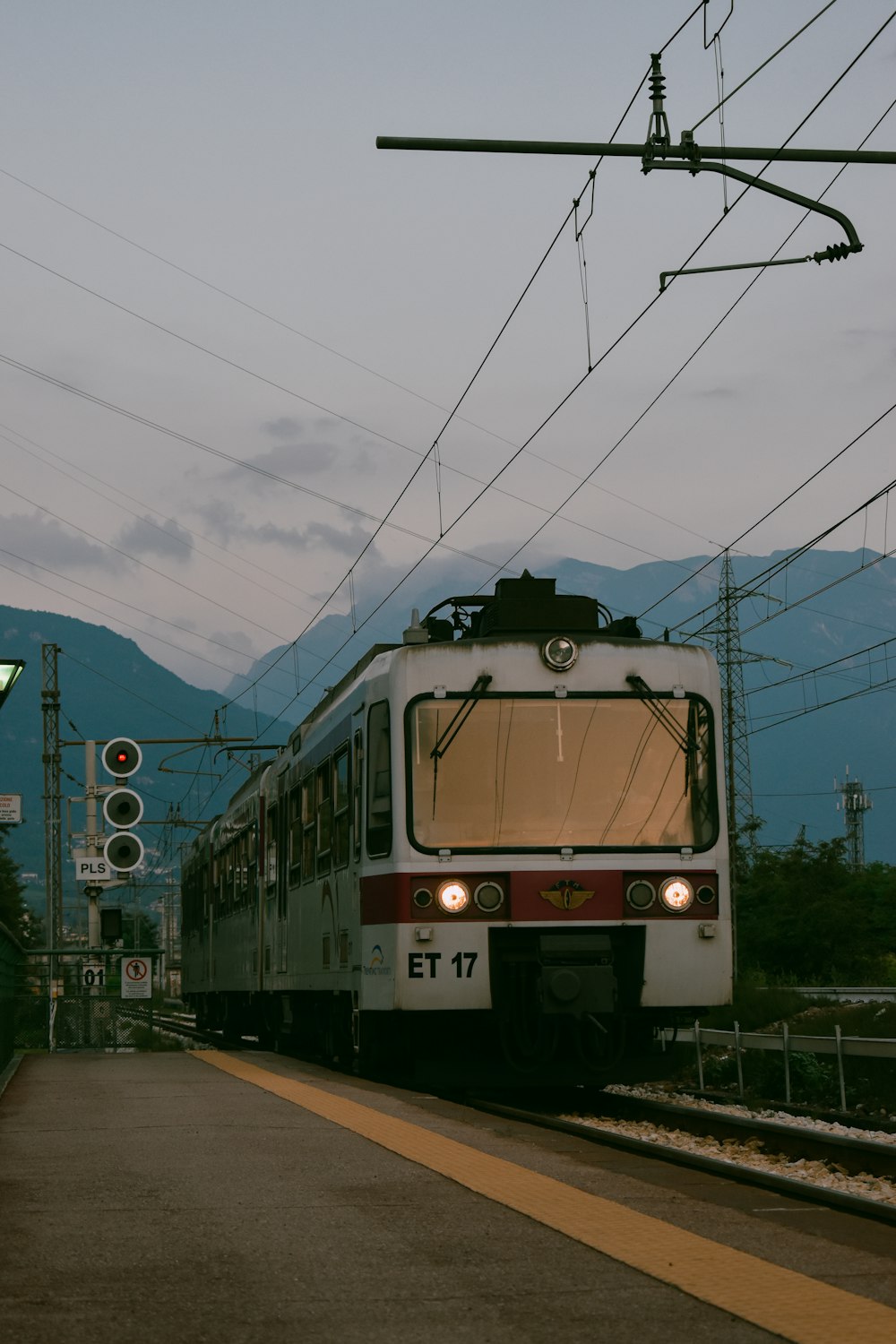 weiß-schwarzer Zug tagsüber auf Bahngleisen unter blauem Himmel
