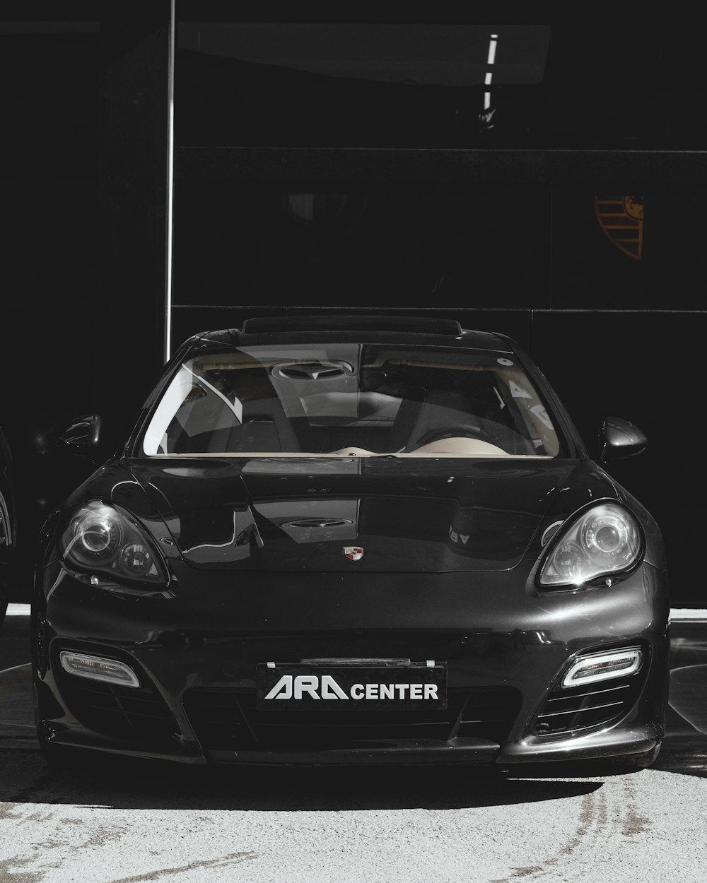 black porsche 911 parked in a black room